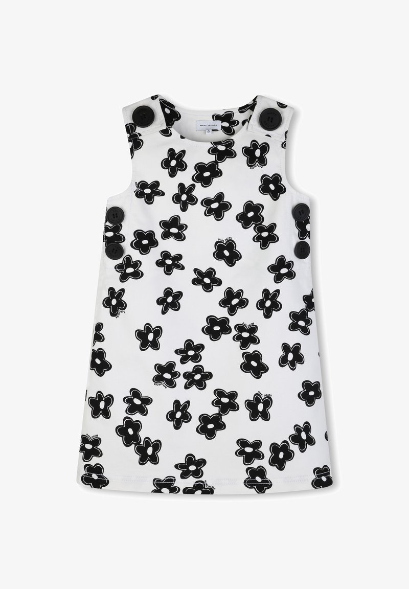 Robe blanche sans manches ornée d'un motif floral noir audacieux et de grandes boutons noirs sur les épaules. Tissu lisse avec une coupe droite.