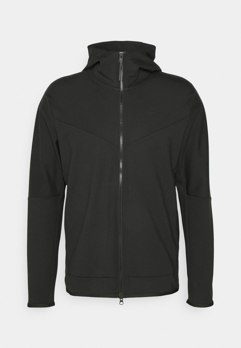 Felpa nera con zip e colletto alto, realizzata in tessuto morbido. Presenta un design con cuciture diagonali e un logo discreto sul petto.