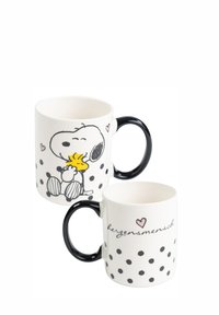 Keramiktasse mit schwarzem Griff, weißem Körper mit Punkte-Muster, einer Illustration von Snoopy und Woodstock sowie dem Text "herzensmensch" in Schreibschrift.