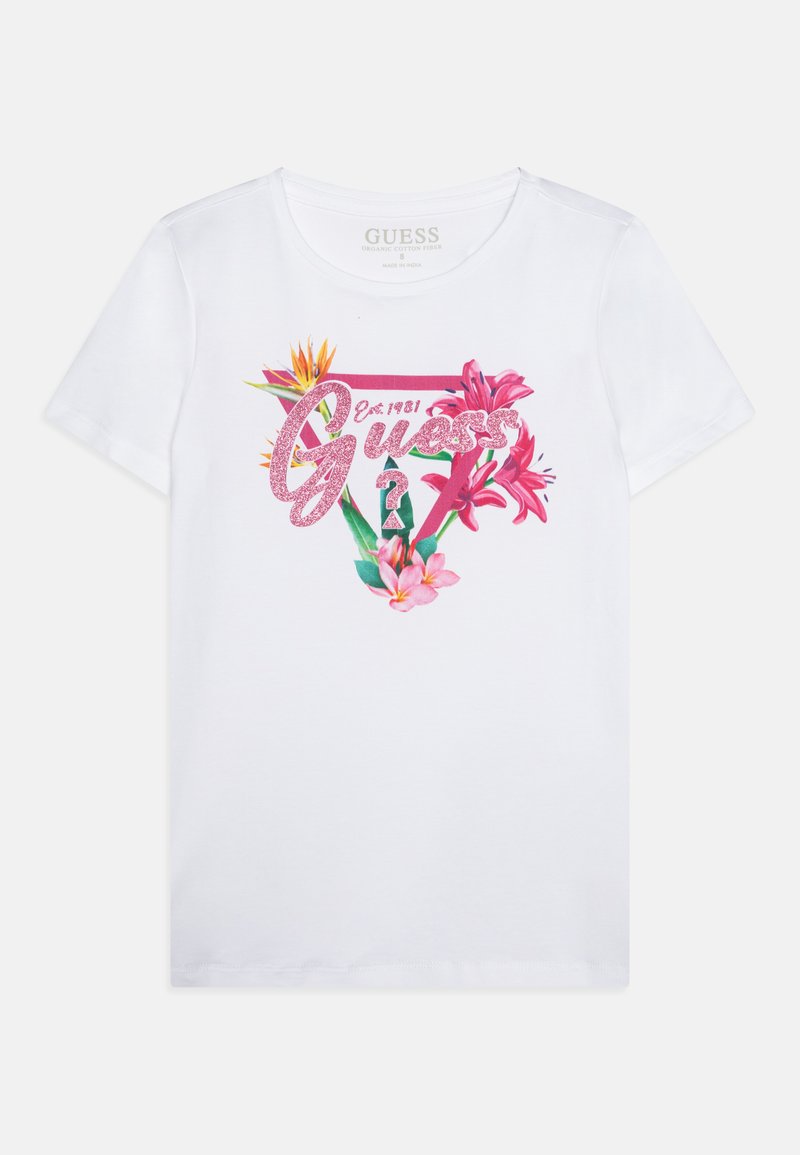White organic cotton t-shirt featuring pink glittery "Guess" logo, surrounded by colorful floral graphics in shades of pink and orange.