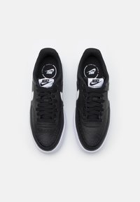 Nike Court Vision Altis sneakers, svart läderöverdelar, vit swoosh, perforerat mönster, svarta snören, vit gummisula.