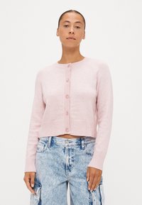 Jasnoróżowy krótszy kardigan wykonany z miękkiego materiału, z prążkowanym wykończeniem, długimi rękawami i sześcioma guzikami na przodzie.