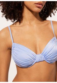 Top de bikini azul claro con diseño fruncido, que presenta tirantes delgados ajustables y un detalle de frente retorcido. Tela suave y texturizada.