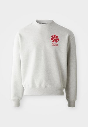 Lys grå hettegenser med ribbestrikkede mansjetter og nederkant. Har en rød grafisk logo på venstre brystområde. Laget av myk stoff.