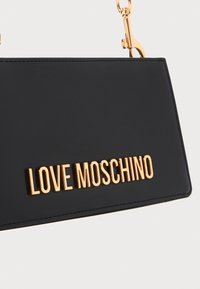 Black matte handbag featuring a gold logo "LOVE MOSCHINO" on the front, with gold chain hardware and stitched detailing.