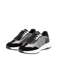 Des baskets de sport noires et argentées, fabriquées en cuir et en daim, avec une finition texturée et une semelle blanche à motif de crampons.