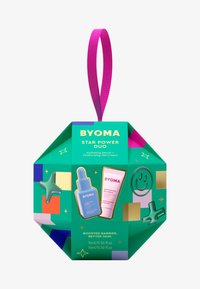 BYOMA Star Power Duo Geschenkbox mit grüner sechseckiger Verpackung und pinkem Band, die ein feuchtigkeitsspendendes Serum und eine Gel-Creme mit bunten Akzenten enthält.