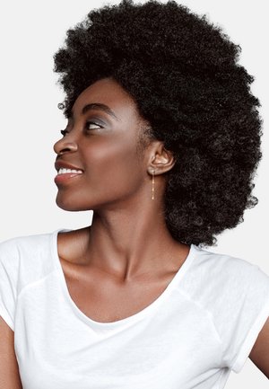 Verstellbare goldene Ohrringe mit Anhänger, getragen von einer Person mit voluminösem, strukturiertem schwarzen Haar. Sie trägt ein einfaches weißes T-Shirt mit einem Rundhalsausschnitt.