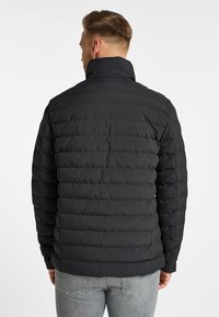 Schwarze Pufferjacke mit hohem Kragen, gestepptem Muster und taillierter Silhouette. Verfügt über einen Reißverschluss, lange Ärmel und ein nahtloses Rückendesign.