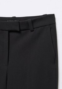 Czarne dopasowane spodnie wykonane z gładkiego materiału, z paskiem w talii z szlufkami oraz bocznymi kieszeniami do przechowywania.