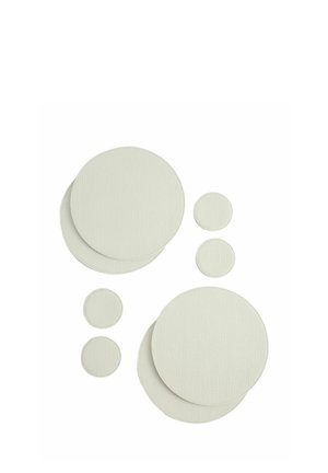 Otto toppe circolari bianche sovrapposte con texture di dimensioni diverse disposte su uno sfondo bianco.
