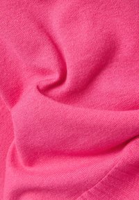 Rosa Stoff mit einer weichen, strukturierten Oberfläche, sanft zerknittert, zeigt eine einfarbige Farbe ohne Muster oder Akzente.