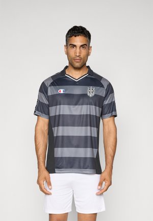 Graues und schwarzes gestreiftes Fußballtrikot mit Kragen, kurzen Ärmeln und Logo auf der Brust; kombiniert mit weißen Shorts.