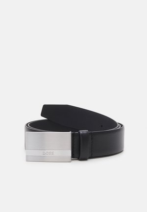Cinto de couro preto com uma fivela retangular de metal prateado com acabamento escovado e um logotipo gravado, oferecendo um design elegante e moderno.