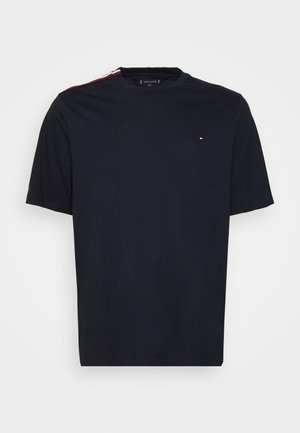 Camiseta de algodón de color azul marino con mangas cortas, cuello redondo y un pequeño logo en el pecho. Presenta detalles de rayas rojas y blancas en los hombros.