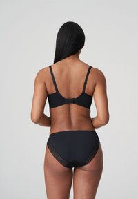 Zwarte kanten beha met bijpassende slip. De beha heeft verstelbare banden en een gladde textuur; de slip heeft kantaccenten.