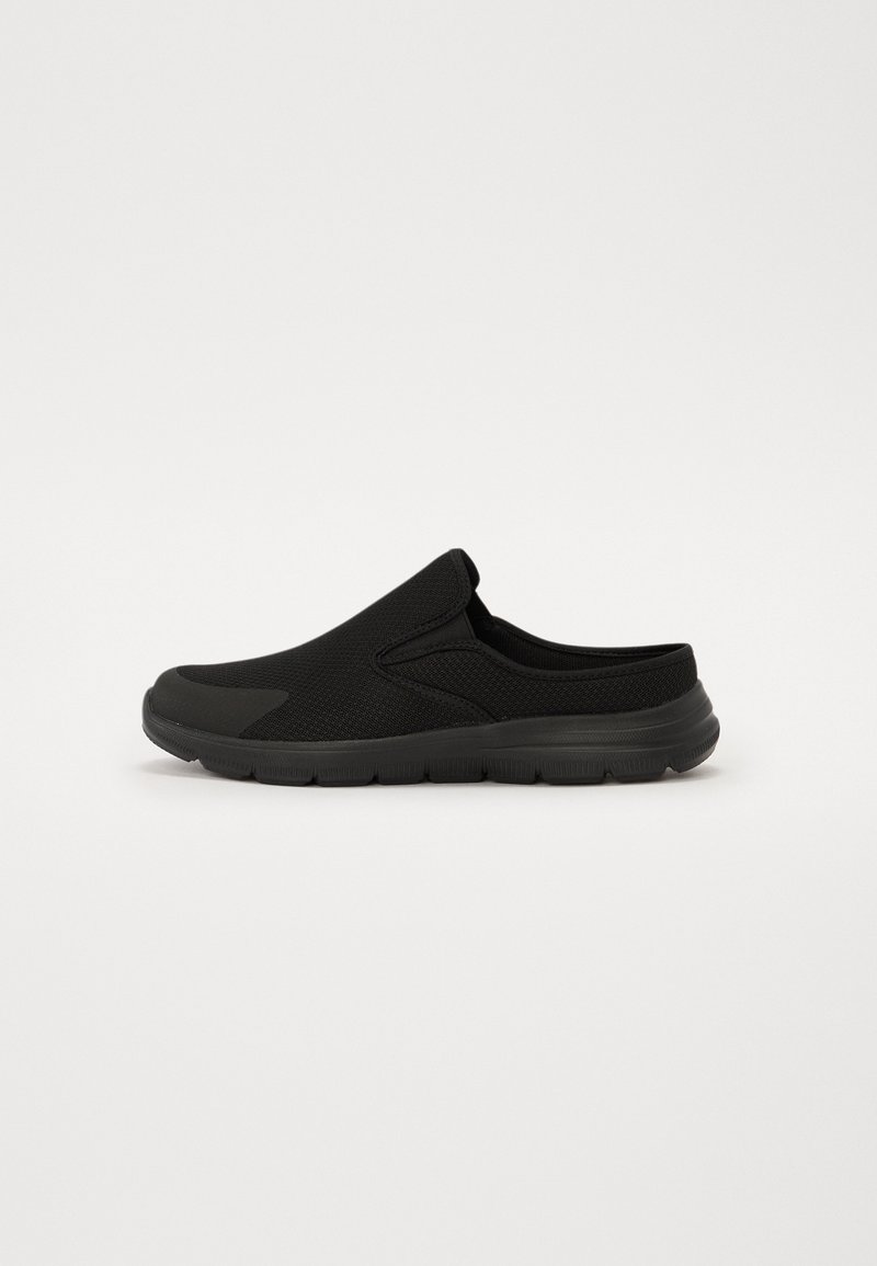Mule noire à enfiler avec semelle flexible, tige en mesh et bout fermé, conçue pour un usage décontracté et un enfilage facile.