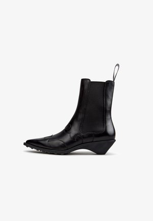 Stivaletto in pelle nera con punta affilata, tacco curvo, pannelli laterali elastici, cuciture decorative e linguetta posteriore.