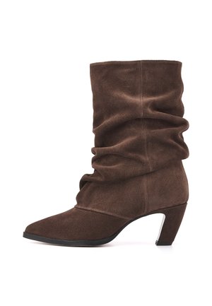 Brown suede mid-calf slouch boot with pointed toe and block heel on a white background.