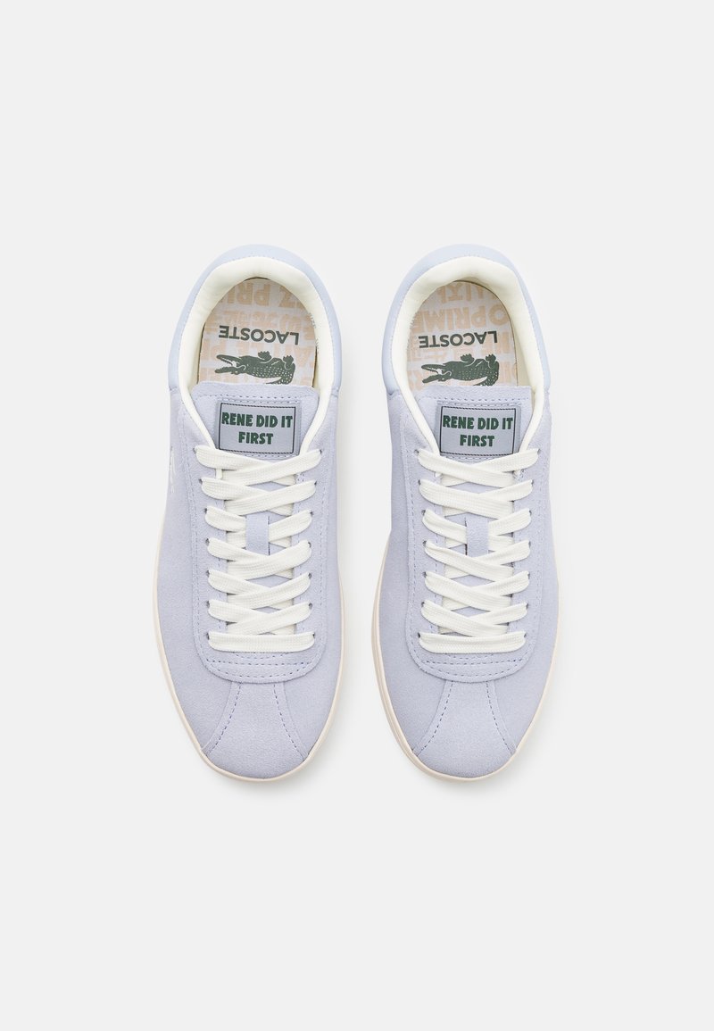 Jasnopurpurowe zamszowe sneakersy z białymi sznurowadłami, z zieloną metką z napisem "RENE ZROBIŁA TO PIERWSZA", oraz wzorzystą wkładką.