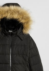 Czarna kurtka puchowa z odpinanym kapturem zakończonym sztucznym futerkiem. Materiał jest gładki, pikowany, z centralnym zamkiem błyskawicznym.