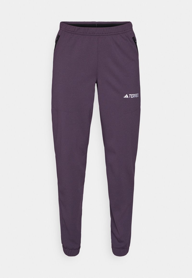 Purple athletic pants with tapered legs, elastic waistband, side pockets, and white "TERREX" logo. Made from lightweight, textured fabric.