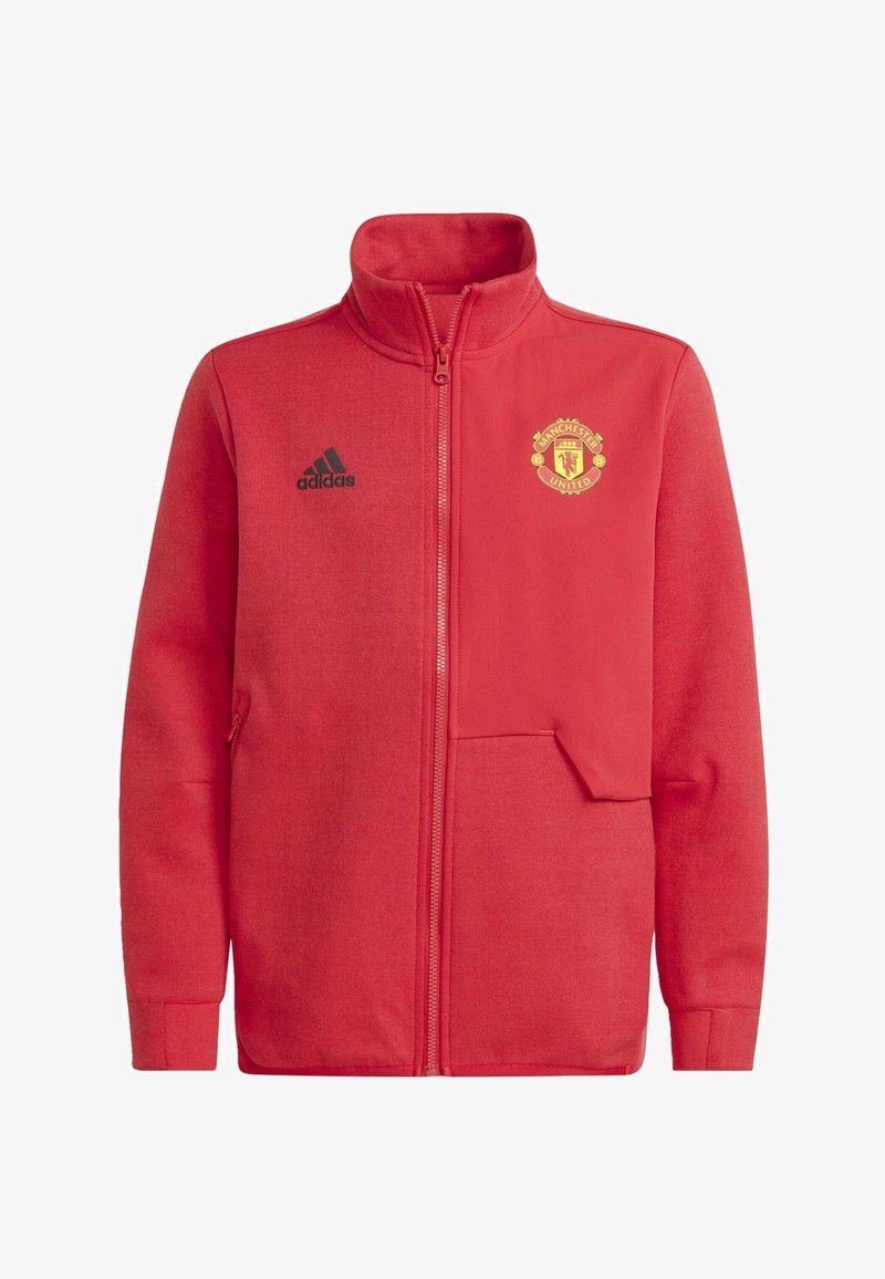 Giacca rossa con zip in pile, con colletto alto, logo Adidas nero e stemma del Manchester United in oro sul lato sinistro del petto.