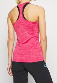 Canotta sportiva rosa con design a schiena a vogatore, realizzata in tessuto strutturato, con spalline nere e vestibilità slim.