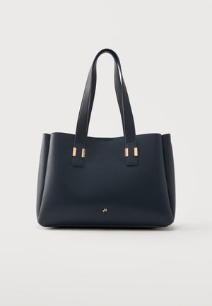 Sac cabas en cuir noir avec double poignée et accents métalliques dorés, présenté sur fond gris clair.