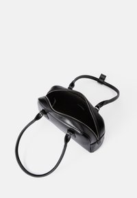 Melna ādas rokassomu ar rāvējslēdzēju, gluda tekstūra, divas rokturi un atvērta iekšpuse, demonstrējot minimālistisku dizainu.