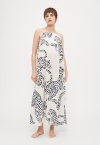 Abito lungo senza maniche in tessuto leggero con un fondo bianco e un motivo a stampa leopardata in nero e blu.