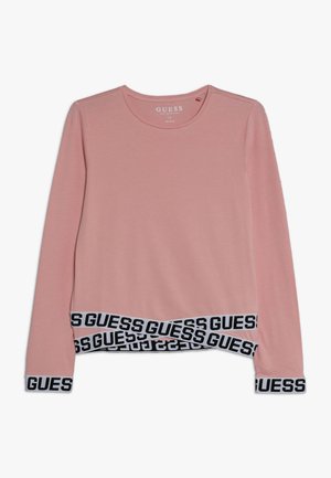 Roze sweatshirt met lange mouwen en een zwarte "GUESS" logoband aan de zoom en manchetten. Gemaakt van zachte, rekbare stof met een ronde hals.
