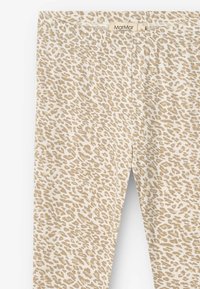 Beige leggings with a leopard print pattern, featuring a soft texture and elastic waistband. Brand label located at the top.