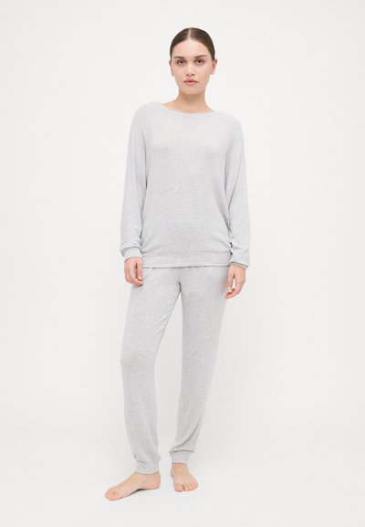 Ensemble de vêtements d'intérieur gris clair comprenant un haut à manches longues avec un col rond et un pantalon ajusté assorti avec des poignets côtelés. Tissu doux et texturé.