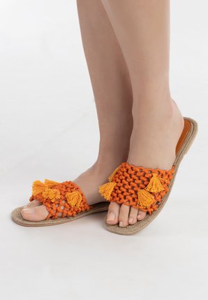 Sandale din țesătură împletită portocalie, cu ciucuri, având o talpă din fibre naturale. Designul cu vârf deschis evidențiază accente decorative.