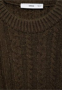 Pull en tricot torsadé marron foncé avec un col rond côtelé et des motifs texturés. L'étiquette indique "MNG", ce qui indique la marque et la taille.