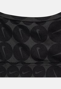 Fekete sportmelltartó, melyen egy sötét szürke kör alakú mintázat ismétlődik a Nike logókkal. Rugalmas anyagból készült, az élein részletes varrással.