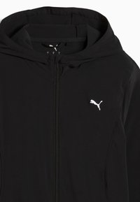 Μαύρο φούτερ με κουκούλα και φερμουάρ, με λευκό λογότυπο Puma στο αριστερό στήθος και ψηλό γιακά.