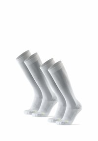 Kniehoge witte sokken met ribbelstructuur en versterkte teengebieden, met kleine neongele accenten aan de zijkanten.