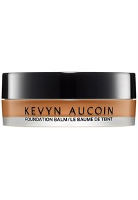 Kevyn Aucoin Foundation Balm in einem runden Glas mit einem schwarzen Deckel. Der Behälter hat einen beige-farbenen Boden mit silberner Schrift. Glatte, cremige Textur.