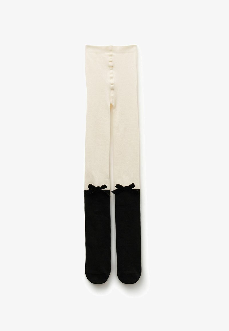 Collant al ginocchio con una parte superiore color crema e una parte inferiore nera, decorati con fiocchetti neri sulla parte superiore. Materiale morbido e elastico.