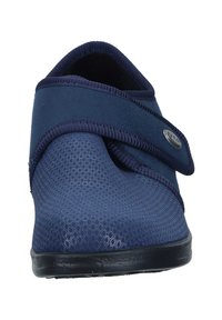 Scarpa in tessuto navy con cinturino in velcro, parte superiore testurizzata con motivo a rombi, forma arrotondata e suola nera piatta.