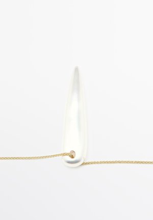 Chaîne en or avec un pendentif allongé blanc brillant, présentant une surface lisse et une extrémité arrondie, passant à travers un petit trou.