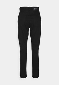 Jeans de denim negro con un corte ajustado, que presentan una cintura de altura media, dos bolsillos traseros y una pequeña etiqueta de la marca en la cinturilla. Textura suave.