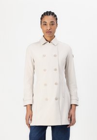 Beige dvouřadový kabát s plochým límcem, kovovými knoflíčky, bočními kapsami a dlouhými rukávy, vyrobený z hladké, lehké tkaniny.