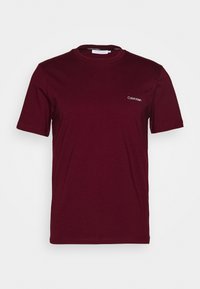 T-shirt in cotone bordeaux con collo rotondo e maniche corte. Presenta un piccolo logo bianco di Calvin Klein sulla parte sinistra del petto.
