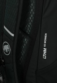 Zaino nero con un motivo esagonale verde testurizzato, chiusura con zip, striscia riflettente e logo di un elefante. Nome del modello "LTHM 15 DONNA" mostrato.