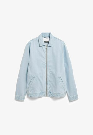 Lichtblauwe denimjas met een rits aan de voorkant, een kraag en twee zijzakken. Heeft een ontspannen pasvorm en subtiele stiksel-details.