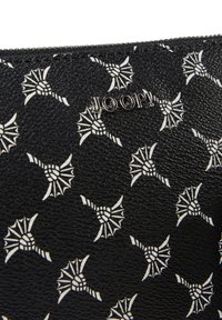 Pochette in pelle nera texturizzata con motivo floreale astratto bianco. Presenta un logo metallico "JOOP!" sulla parte anteriore. Chiusura con zip nella parte superiore.