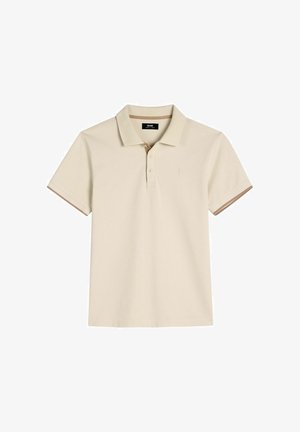 Beżowa koszulka polo z krótkim rękawem, kołnierzykiem, trzema guzikami oraz subtelnym brązowym obszyciem na krawędziach rękawów i wewnętrznej stronie kołnierzyka.